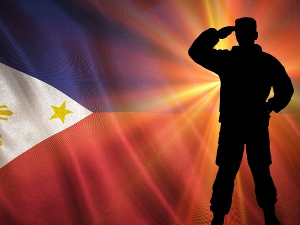 A silhouette of a soldier saluting beside the Philippine flag, ideal for illustrating formal civic protocols in an event program flow in Quezon City.