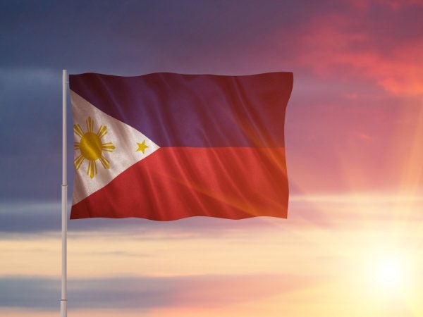 The national flag of the Philippines waving at sunset, symbolizing heritage and national pride for an event program flow in Quezon City.