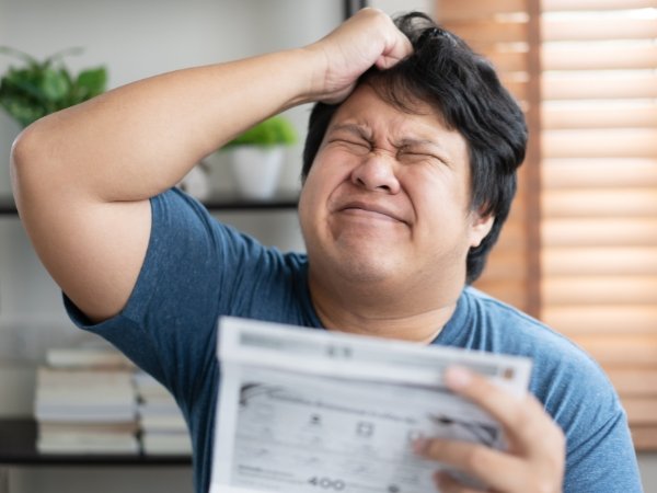 A person looking stressed while reviewing a wedding reception layout. A reminder not to forget allocating space for suppliers when using a wedding venue capacity guide in Quezon City.